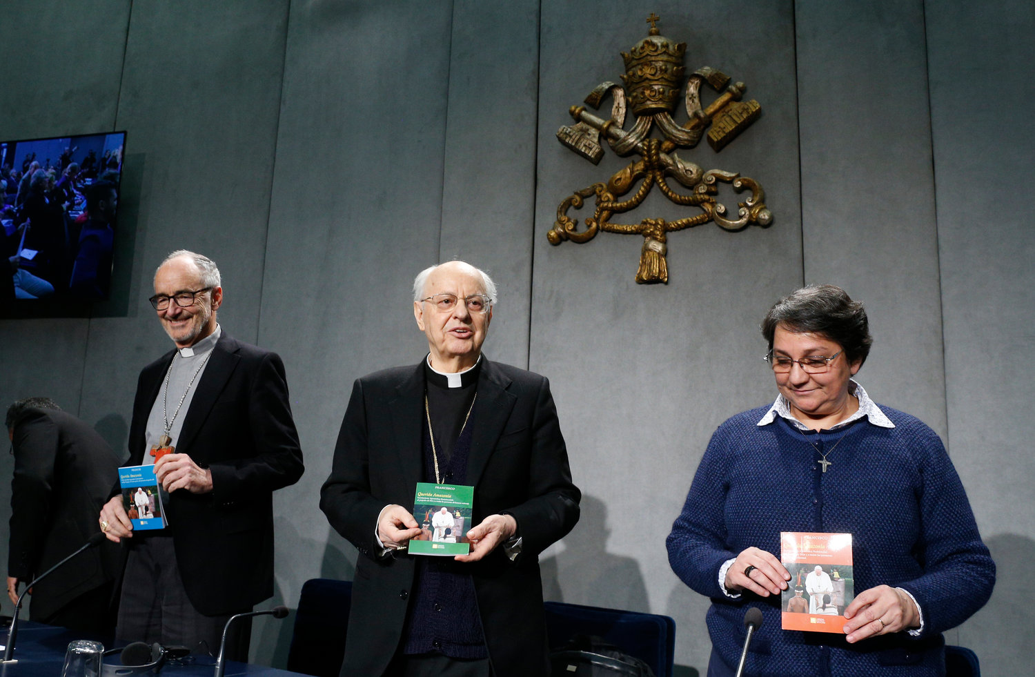 Cardinal Michael Czerny, Cardinal Lorenzo Baldisseri, and Sister Augusta de Oliveira hold copies of Pope Francis' apostolic exhortation, "Querida Amazonia" (Beloved Amazonia), during its release at a news conference at the Vatican Feb. 12, 2020. The document contains the pope's conclusions from the 2019 Synod of Bishops for the Amazon.